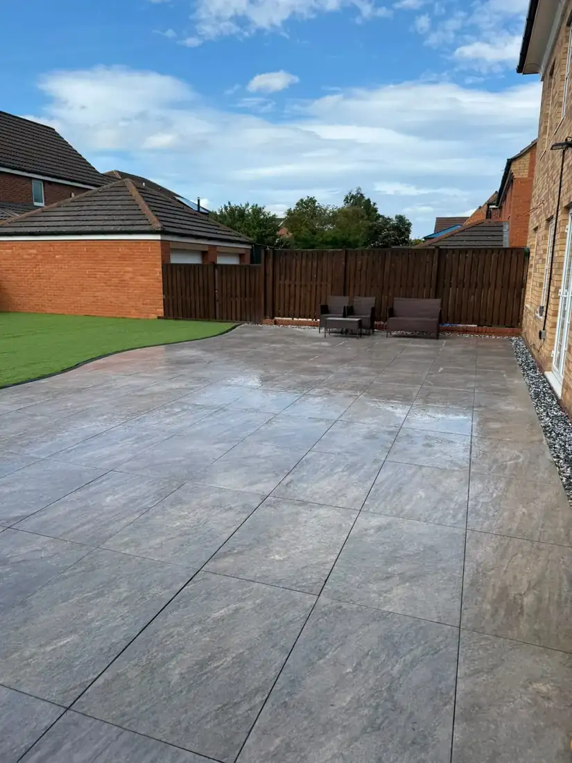 Grey porcelain patio with curved lawn edge